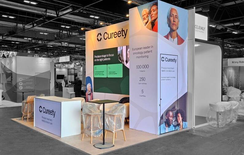 Totem du stand Cureety au congrès ESMO à Madrid, chiffres clés et portraits de patients